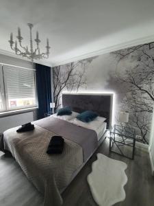 a bedroom with a large bed and trees on the wall at R&S Apartments Bremen in Bremen