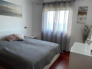 biała sypialnia z łóżkiem i oknem w obiekcie Apartment Ocean Gardens w Caniço