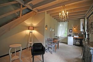 a living room with a table and chairs and a chandelier at LA PETITE CHARMILLE in Châteauponsac