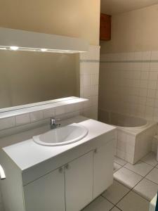 a bathroom with a white sink and a tub at Appartement centre ville Luz Saint Sauveur T4 pour 10 personnes in Luz-Saint-Sauveur