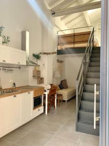 a kitchen with a staircase and a living room at Metroloft in Bologna