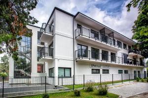 un immeuble d'appartements avec balcon et clôture dans l'établissement W&K Apartments - Harmony Suite, à Koszalin