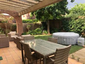 een patio met een tafel en stoelen en een matras bij Vil·la La Garriga Termal Congost in La Garriga