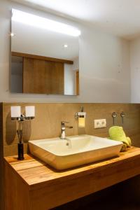 baño con lavabo blanco grande y espejo en Haus Ganeu, en Gaschurn