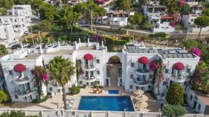  Elle offre une vue aérienne sur une grande maison blanche dotée d'une piscine. dans l'établissement La Brezza Suite & Hotel, à Akyarlar