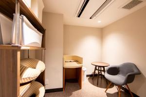 a room with a bunk bed and a table and chairs at karaksa hotel TOKYO STATION in Tokyo