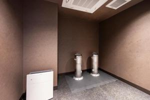 a corner of a bathroom with a toilet and a radiator at karaksa hotel TOKYO STATION in Tokyo