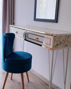 una scrivania con sedia blu e specchio di Eral Apartment Mamaia a Mamaia