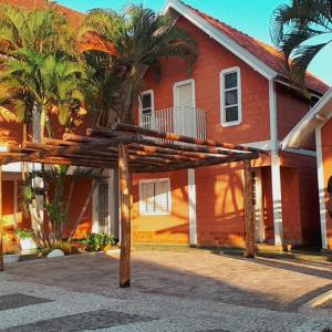 a wooden pergola in front of a house at Chalé Apart Hotel in Bonito