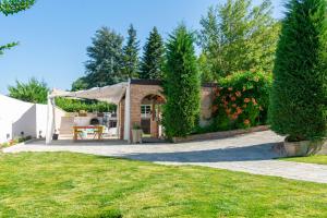 uma casa com um pátio e um jardim em I Tre Tramonti em Acqui Terme