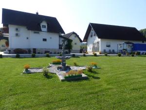 a fountain in a yard in front of a house at House Pox in Plitvička Jezera