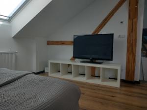 einen Fernseher auf einem weißen Stand in einem Schlafzimmer in der Unterkunft Bad Aibling City Apartment DG in Bad Aibling