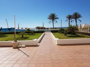a walkway with palm trees and the ocean in the background at Apartment Sea View 20m to beach - TOP Quarteira ALGARVE in Quarteira