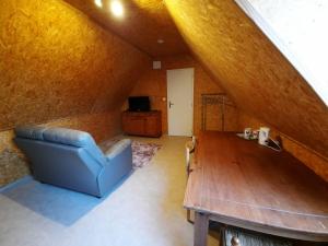 sala de estar con sofá azul y mesa de madera en La Flandre entre plaine, mer et marais, en Rubrouck