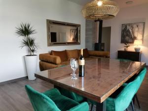 a living room with a wooden table and green chairs at Luxury apartment Tamaris by the sea in Nin