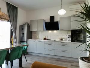 a kitchen with white cabinets and a dining table at Luxury apartment Tamaris by the sea in Nin +40 photos