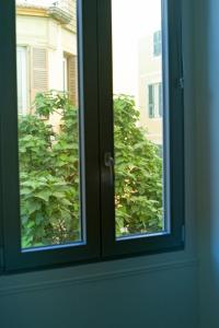 a window with a view of a bush at Bon'appart in Ajaccio