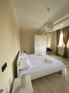 a bedroom with a large white bed and a table at Vila Eleonora Beograd in Belgrade