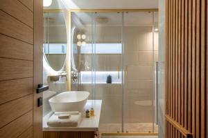 a bathroom with a glass shower with a sink at The Blossom-Premium living residence at Heraklion in Heraklio Town