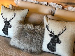two pillows with deer antlers on a couch at Coral Cabins in Dunvegan