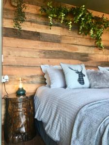 a bedroom with a bed with a wooden wall at Coral Cabins in Dunvegan
