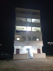 a tall building at night with the lights on at MD APARTMANI CANJ in Čanj