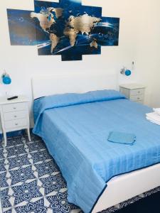 Schlafzimmer mit einem Bett mit blauer Decke in der Unterkunft Villa Zaffiro in Lampedusa