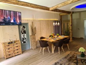 Bambu Lodge @ Ossiachersee في بودينسدورف: غرفة طعام مع طاولة وكراسي خشبية
