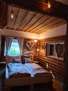 1 dormitorio con 1 cama con un signo cardiaco en la pared en Bambu Lodge @ Ossiachersee en Bodensdorf