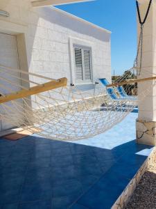 a hammock on the side of a house at Villa Zaffiro in Lampedusa