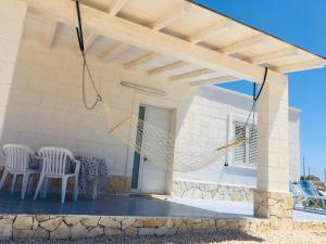 a patio with two chairs and a hammock at Villa Zaffiro in Lampedusa