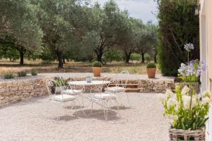 een patio met een tafel, stoelen en bomen bij La Petite Ruche, 1 bedroom Gite in the Luberon in Apt