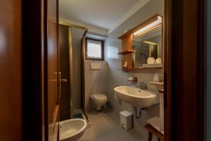 a bathroom with a sink, toilet and bathtub at Hotel Triolet in Courmayeur