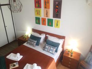 アルブフェイラにあるFisherman´s beach apartmentのベッドルーム1室(ベッド1台、テーブル2台、ランプ2つ付)