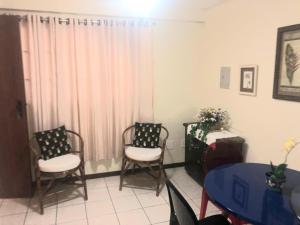a room with two chairs and a table and a window at Atlântico Flat Apto 103 in Natal