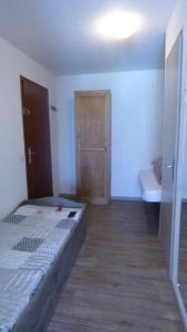 1 dormitorio con 1 cama y suelo de madera en QUEYRAS en Ceillac