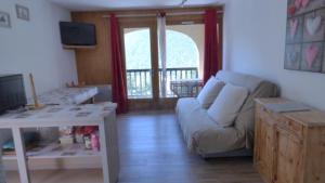 uma sala de estar com um sofá e uma mesa em QUEYRAS em Ceillac