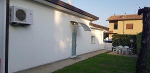 a white house with a green door and a yard at Casa Nicky in Abano Terme