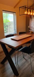 a dining room table with chairs and a window at Buiten Huisje aan de Vaart 1 in Matsloot