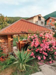 a garden with a pavilion with pink flowers at Apartment Beganovic-Centar in Kulen Vakuf