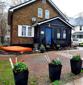 a black house with flowers in front of it at Blue Spruce Bed and Breakfast in Gravenhurst