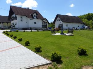 a green yard with two benches in front of a house at House Pox 2 in Plitvička Jezera