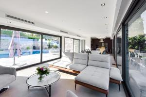 uma sala de estar com um sofá e uma mesa em SERRENDY - Custom villa with swimming pool em Mandelieu-la-Napoule