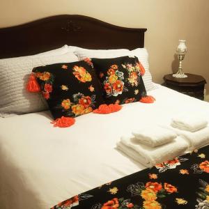 a bed with two black pillows with flowers on it at Blue Spruce Bed and Breakfast in Gravenhurst