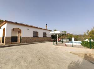 a white house with a pool and a fence at Casa Rural Cerca Del Caminito Del Rey Ardales in Ardales