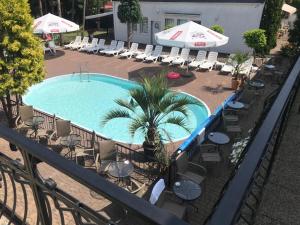 an overhead view of a swimming pool with chairs and umbrellas at Oaza Resort in Stegna