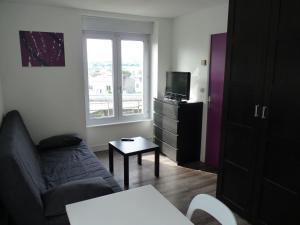 sala de estar con sofá y TV en Résidence Albert Premier, en Brest