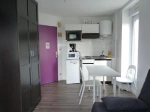 una pequeña cocina con mesa y puerta morada en Résidence Albert Premier en Brest