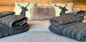 a bed with grey blankets and pillows on it at Coral Cabins in Dunvegan