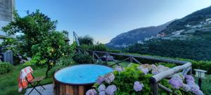 a garden with a table and flowers at Suite Lia - Private Room with garden and tub close to Villa Eva e Cimbrone, Ravello in Ravello